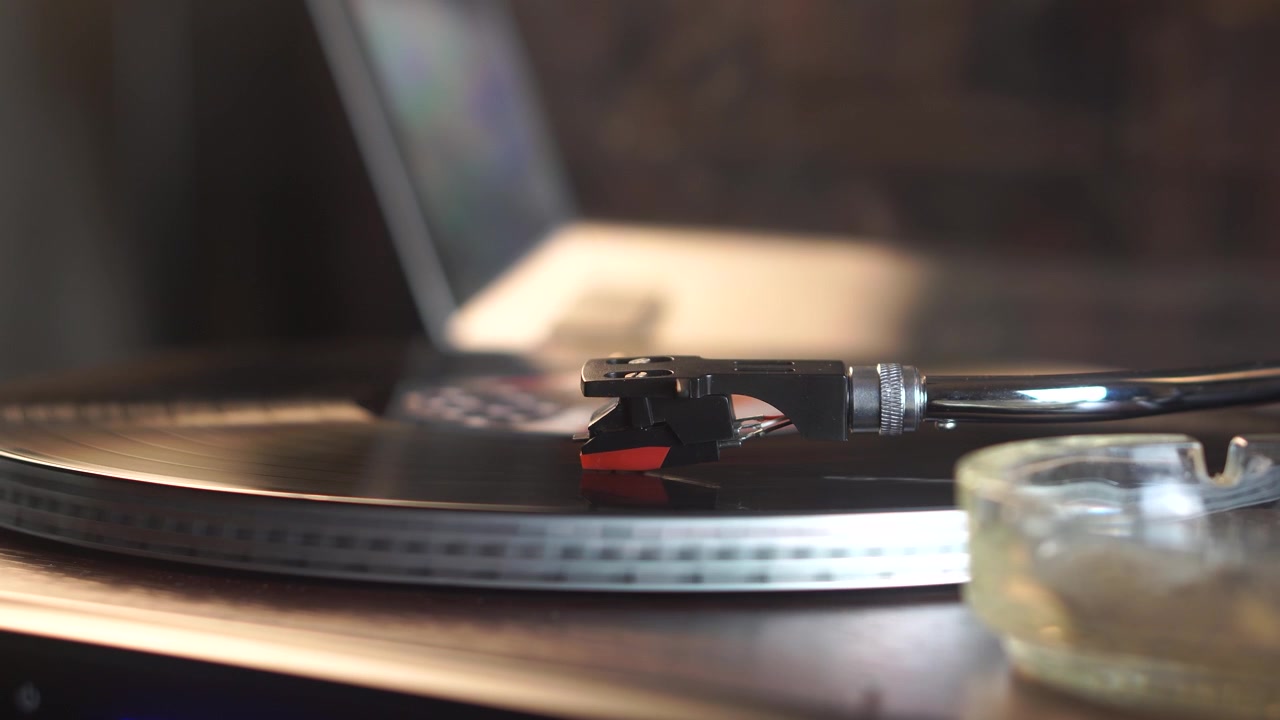 Disco in vinile con adesivo della bandiera USA che suona su un giradischi e fumo di sigaretta nell'ambiente della stanza