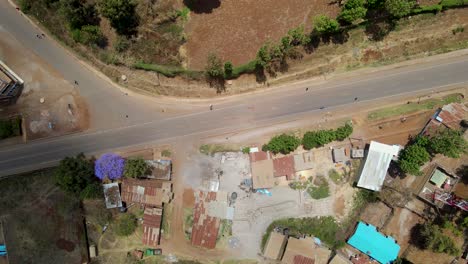 Aerial-view-of-a-town-and-sunlit-fields,-golden-hour-in-rural-Africa---tracking,-drone-shot