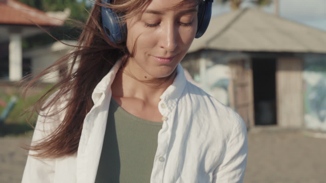 Woman in Earphones on Windy Beach