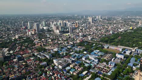 flyover drone shot of buildings and cityscape of cubao, quezon city, philippines during daytime