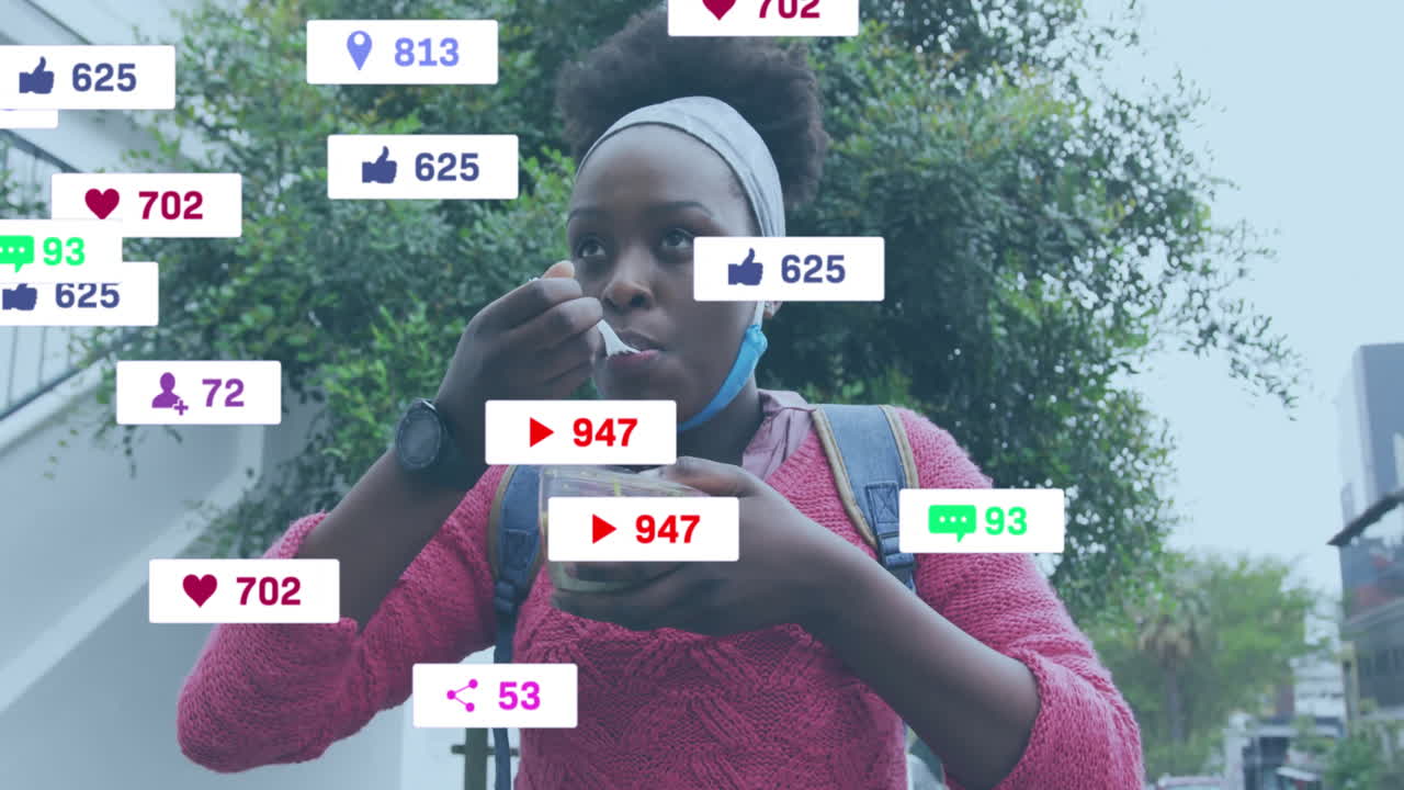 Eating salad outdoors, woman viewing animation of social media notifications