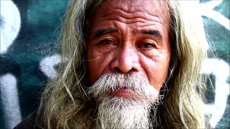 antipolo city, philippines – july 22, 2019: a mature filipino man with lots of head and facial hair stop and pose for the camera.