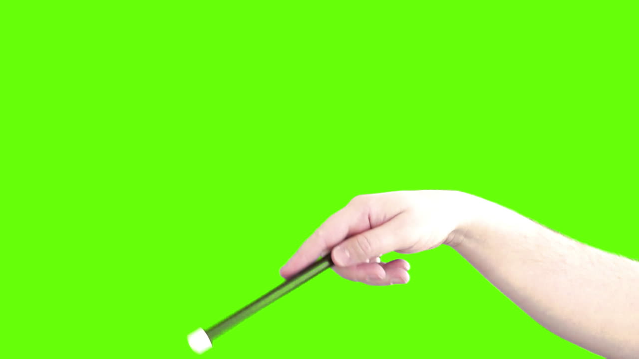 Hand holding a magic wand on a green screen