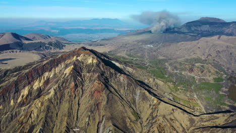 wide drone shot of mountain range near the volcano mount aso