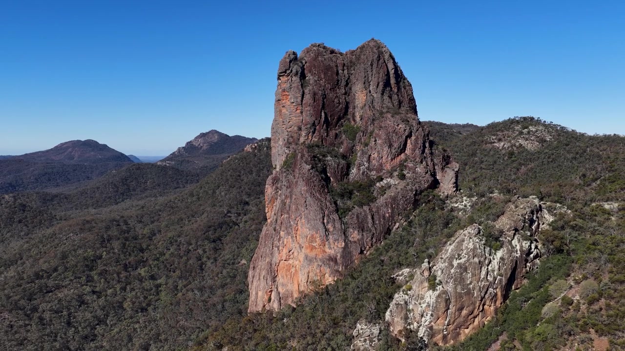 Ampia ripresa aerea del neck vulcanico The Breadknife e del terreno accidentato nel Parco Nazionale Warrumbungle.