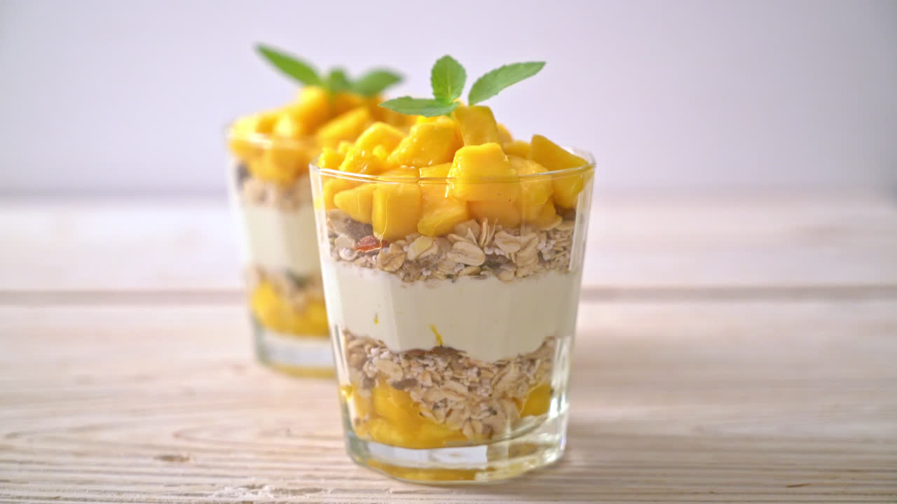 yogur de mango fresco con granola en vidrio - estilo de comida saludable