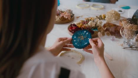 woman creating resin art coaster