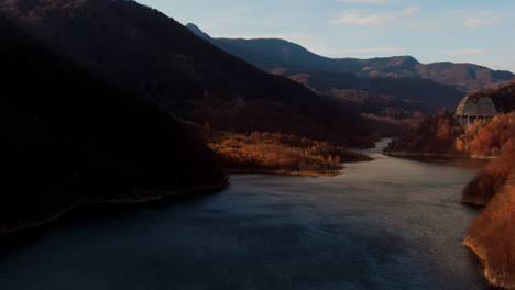 Aerial-shot-of-beautiful-sun-rays-coming-down-between-the-mountains-over-the-lake