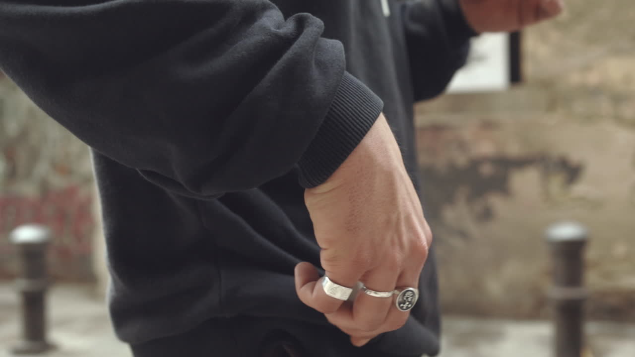 Uomo caucasico con i capelli lunghi accende una sigaretta, cinematografico, al rallentatore.