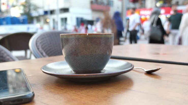 eine tasse kaffee auf einem kaffeetisch draußen