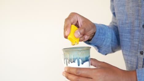 a man adds a sugar packet to a cup of coffee