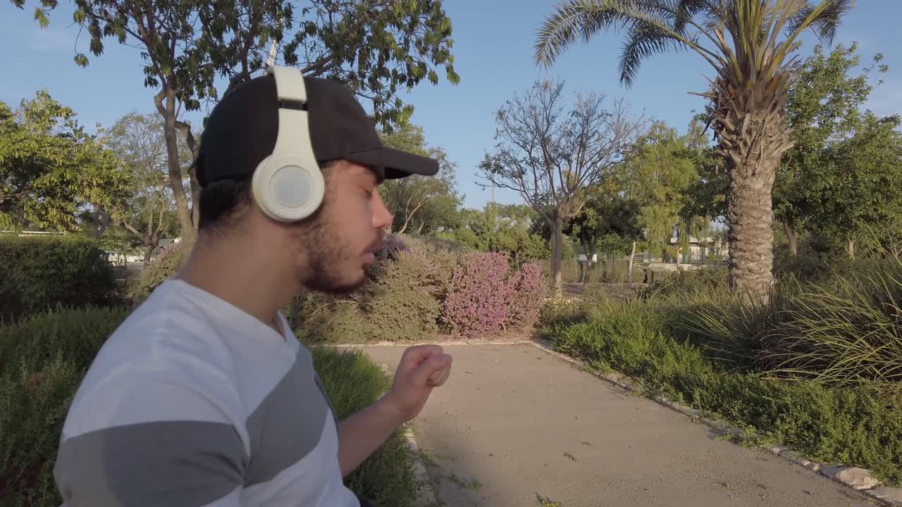 Young Man Listening to Music in a Park