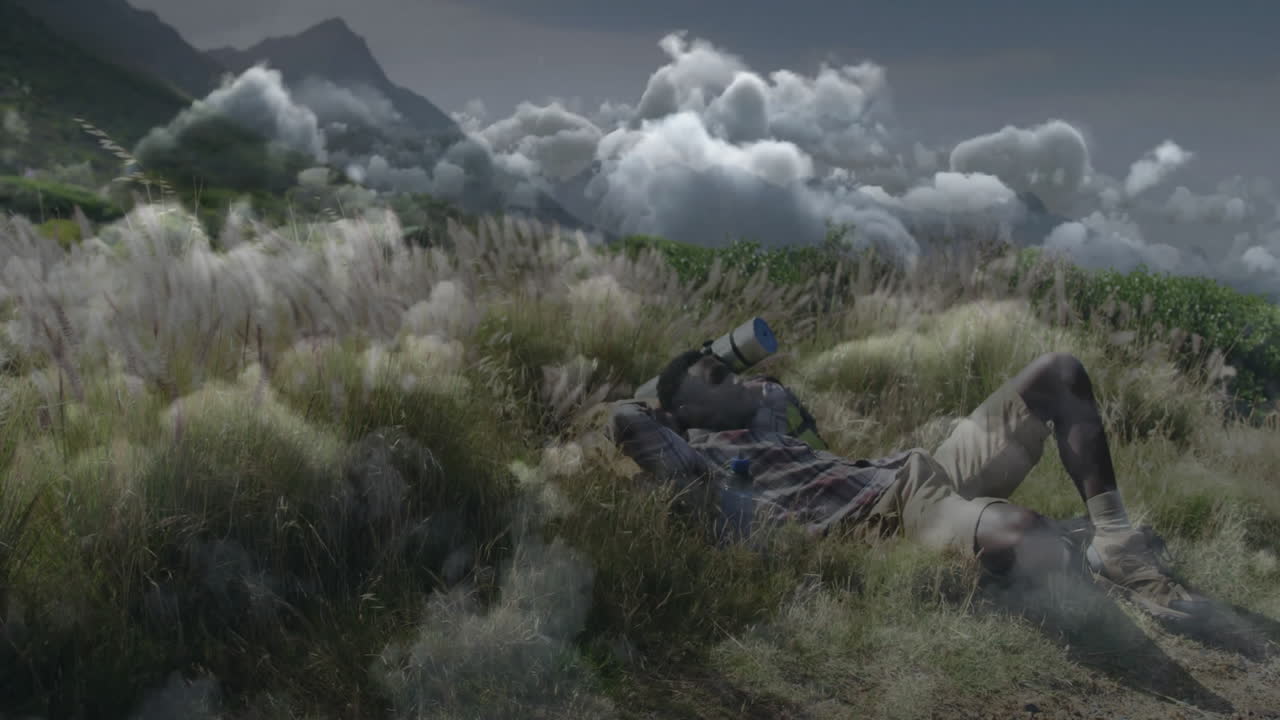 man lying on meadow drinking water bottle, showing animated health icons and mountain chart