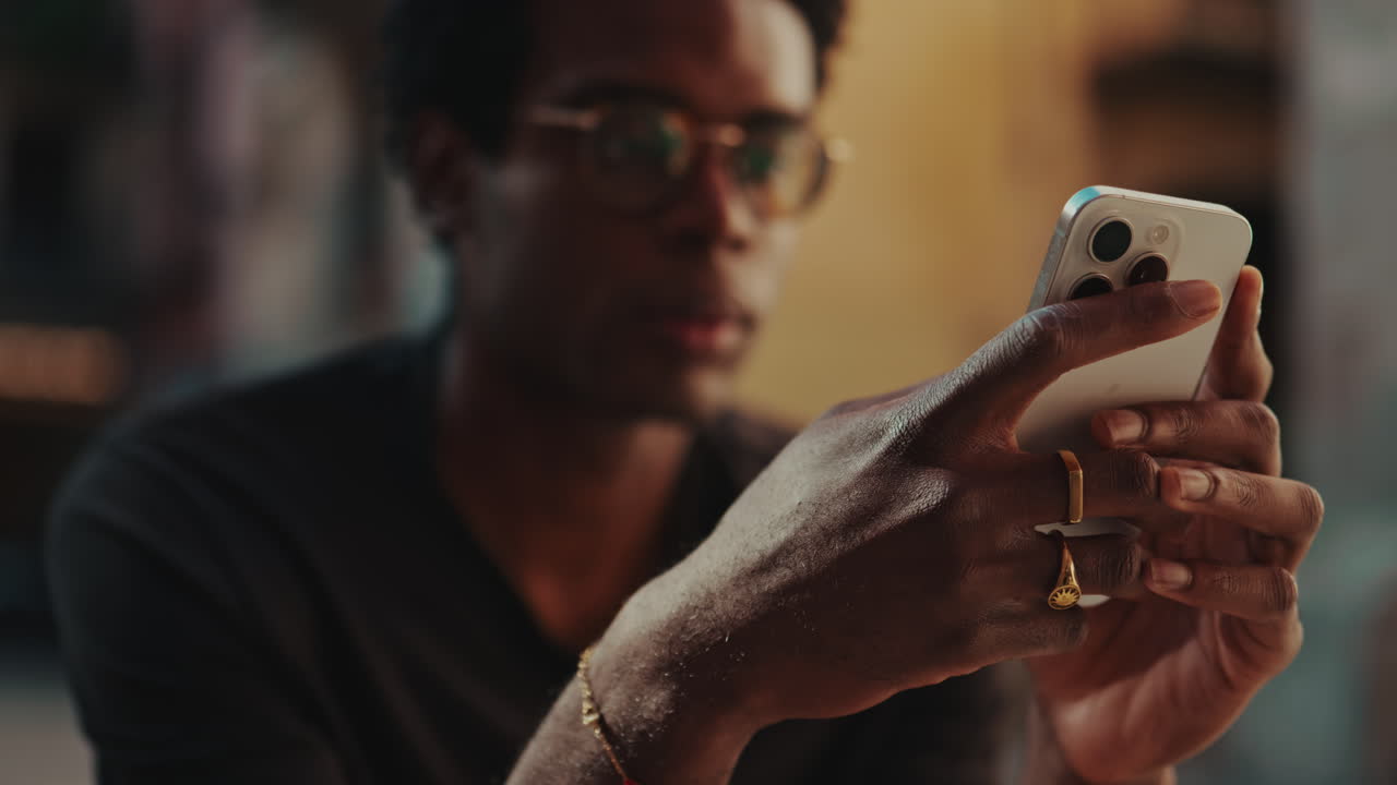 Close-up of Young Black Man Using Smartphone