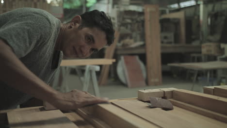 carpenter polishing wood using sandpaper