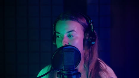 woman singing into a microphone in a recording studio