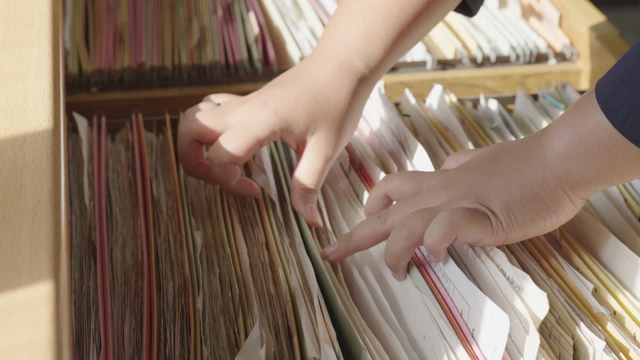 Female staff searching for documents in the office filing cabinet