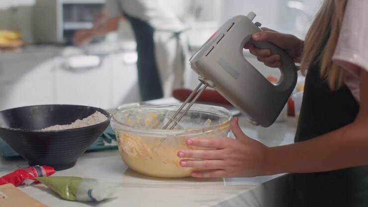 Bambino irriconoscibile che impasta la pasta per i biscotti