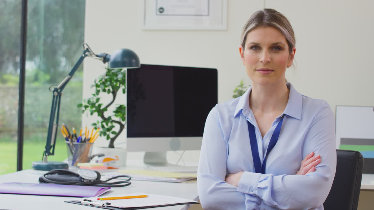 retrato de una mujer médico o médico de cabecera en la oficina sentada en el escritorio con los brazos cruzados