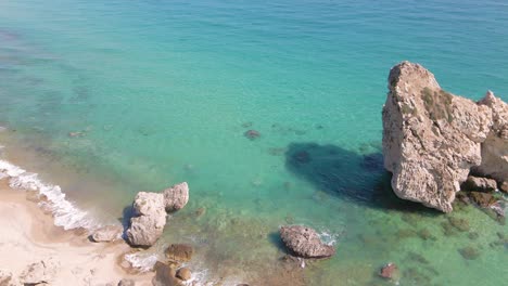 overhead drone clip over beautiful beach with waves crushing the shore in kavala, macedonia, greece