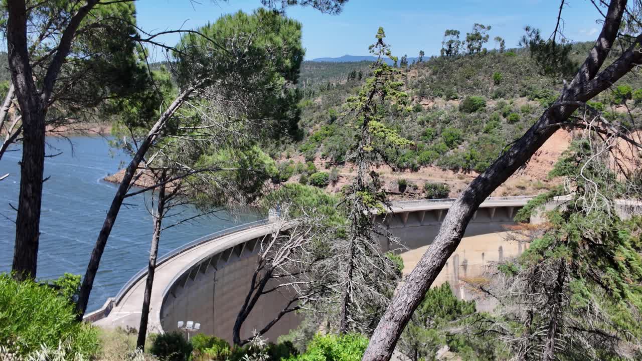 Natural environment featuring Barragem da Bravura with reservoir, forest, and clear sky.