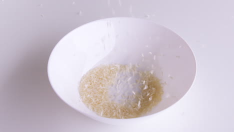 Rice-grains-that-have-been-cleaned-of-husks-into-bowls-ready-to-be-cooked-and-consumed,-rice-is-the-staple-food-of-people-in-Asia