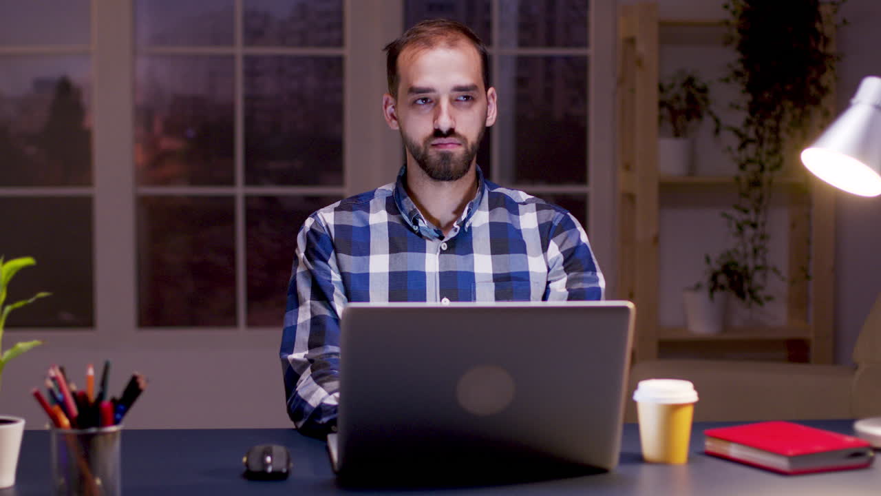 hombre trabajando en la computadora portátil por la noche