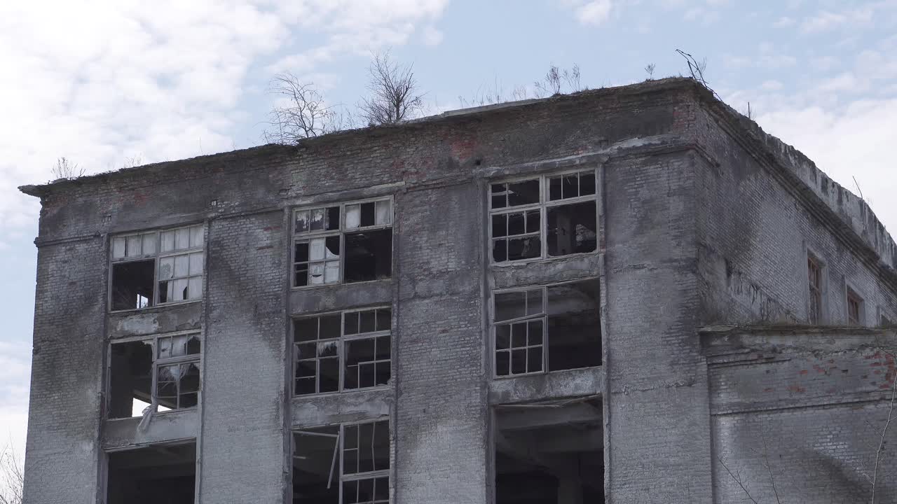 Old brick ruined high-rise building with broken windows and cracked walls. Ruins of the city, an industrial enterprise