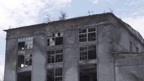 old brick ruined high-rise building with broken windows and cracked walls. ruins of the city, an industrial enterprise