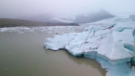el avión no tripulado vuela alrededor de un gran iceberg para revelar el parto del glaciar de marea