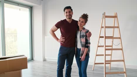 Portrait-of-smiling-couple-moving-in-new-flat