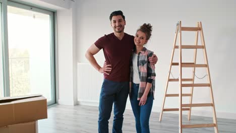 portrait of smiling couple moving in new flat