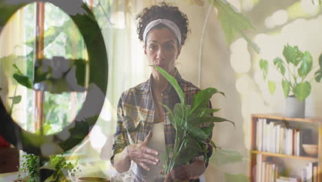 animación de plantas sobre una mujer biracial envasando plantas y vlogging