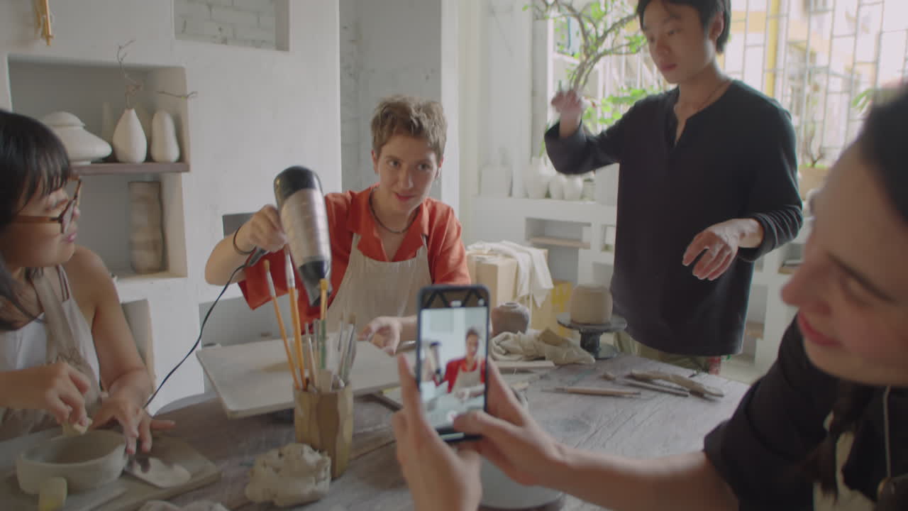Woman Taking Picture of Friend on Pottery Lesson