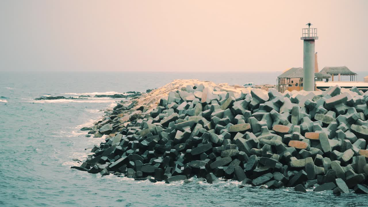 바다 풍경에서 콘크리트 파도와 등대. 폭풍우의 바다에서 등대.