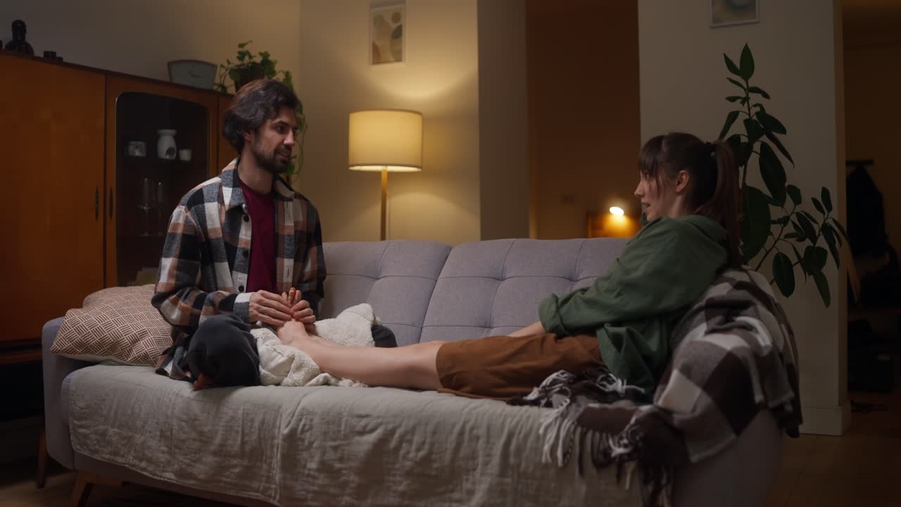 Couple relaxing at home with foot massage