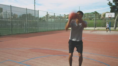 Black-guy-throwing-basketball-ball-into-ring