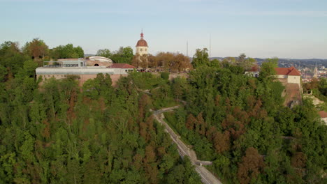 Luftbild-Fliegend-Wegziehen-Vom-Glokenturm-Auf-Dem-Grazer-Waldpark-Schloßberg