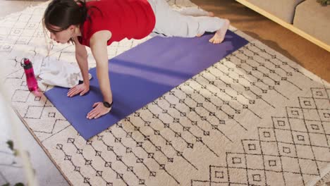 caucasian non-binary transgender woman practicing yoga, stretching