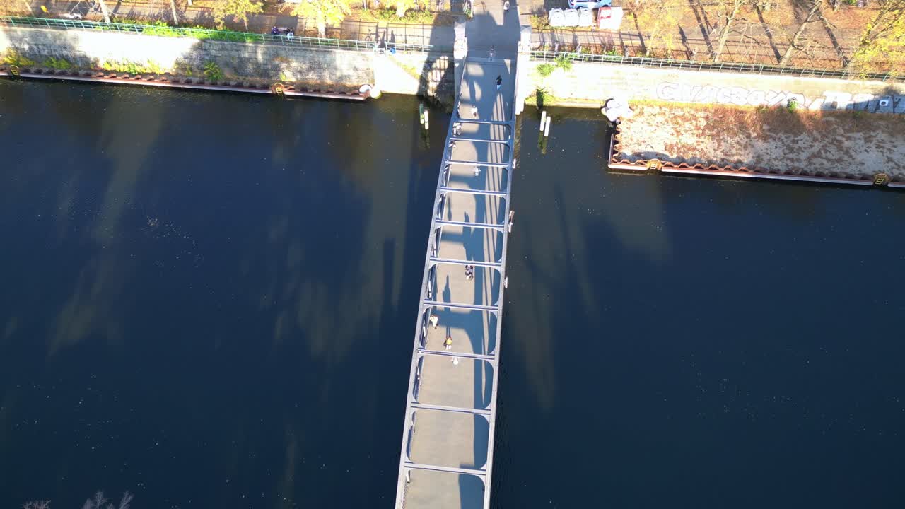 Aerial View of People Walking on a Bridge Over a River in the City
