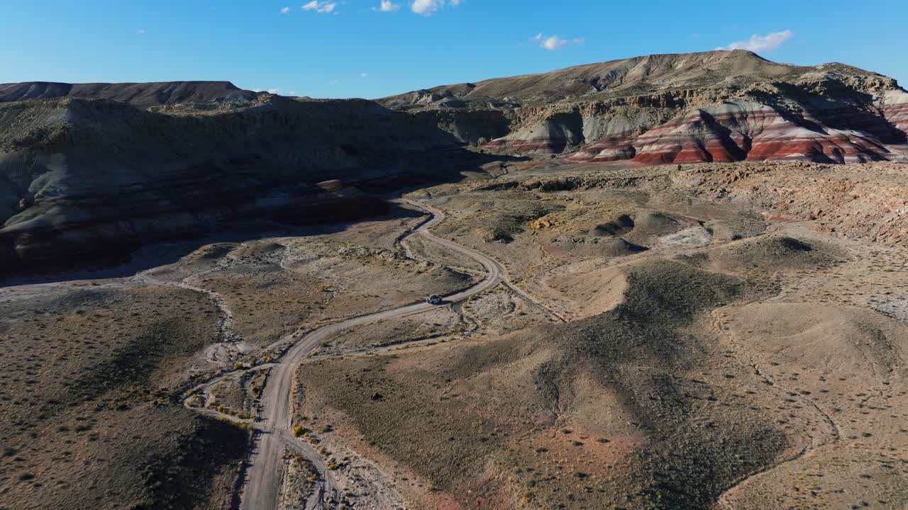 vehículo conduciendo fuera de carretera a través de las colinas del desierto en utah, estados unidos - disparo aéreo de dron