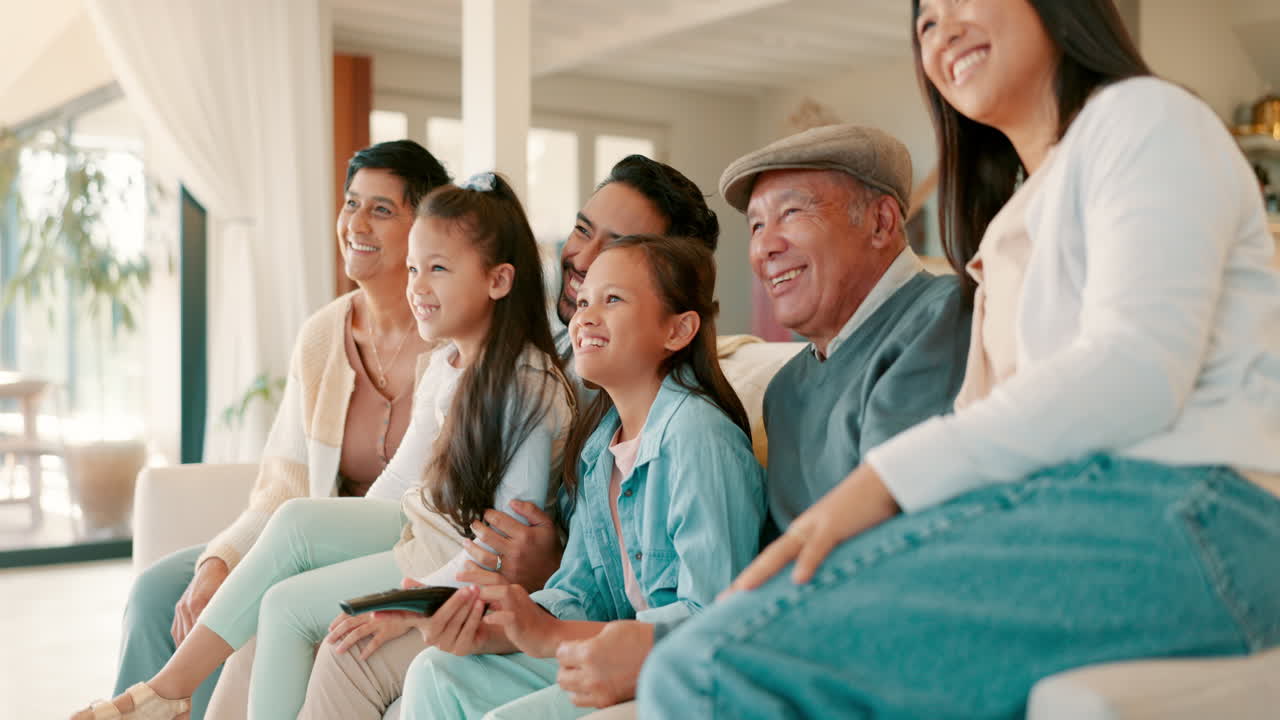 편안하고 행복하고 큰 가족이 소파에서 tv를 보고 있습니다.