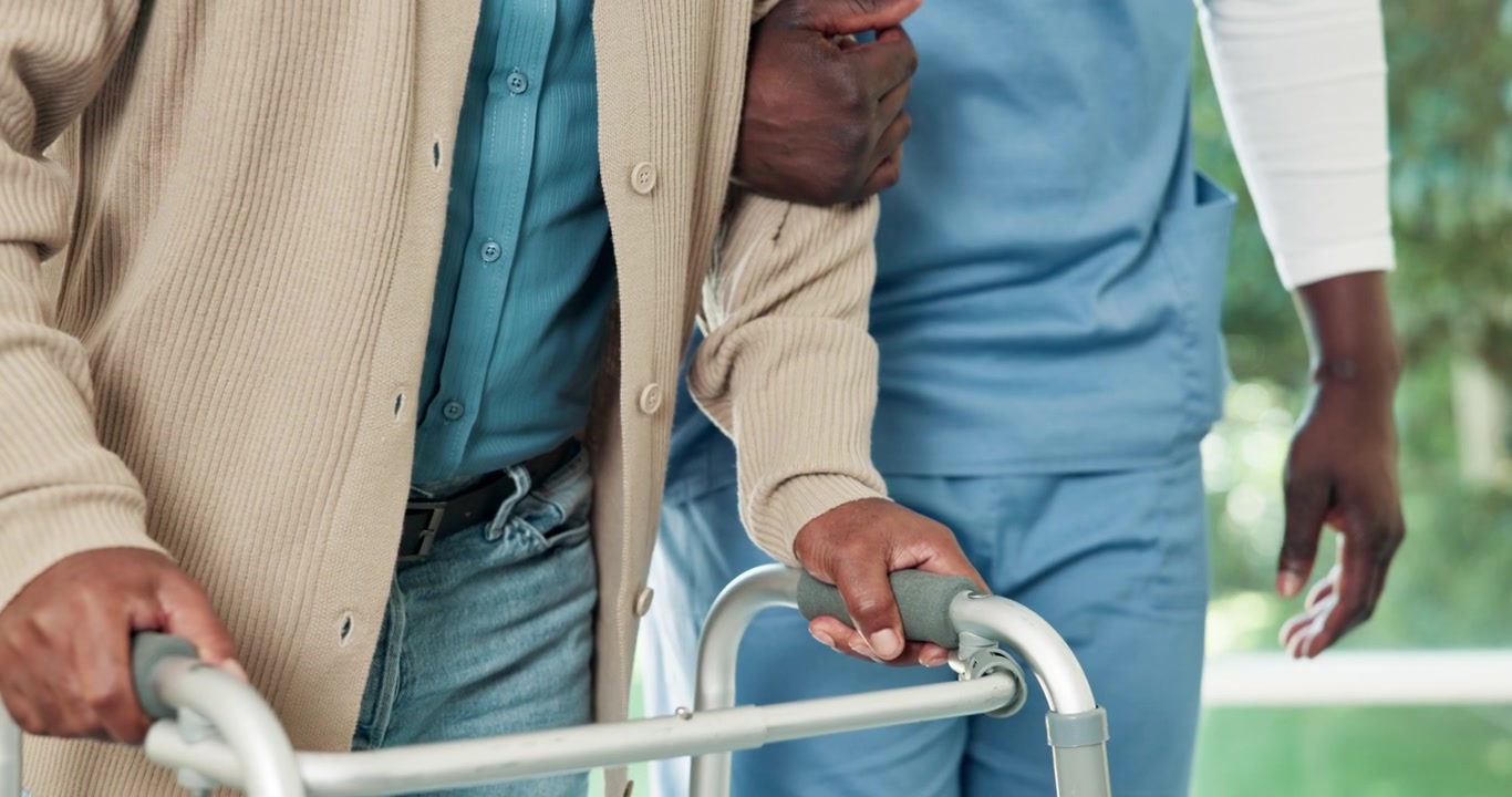 Caregiver Assisting Senior Man Walking With a Walker