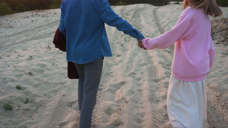 romantic couple holding hands by the sand