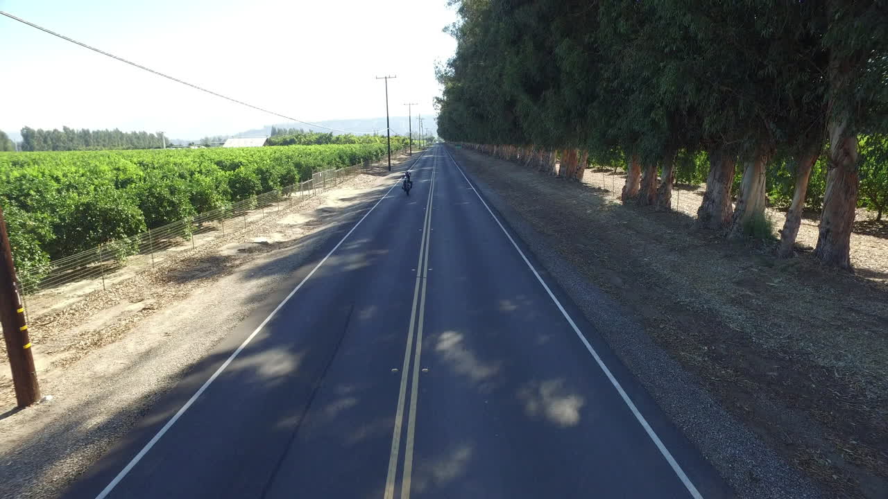 캘리포니아 도로에서 터무니없는 휠리를 하고 있는 오토바이 스턴트맨 위의 공중