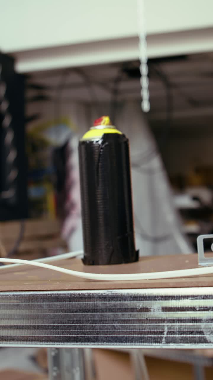 Vertical video Close up of spray cans in empty basement with graffiti drawings