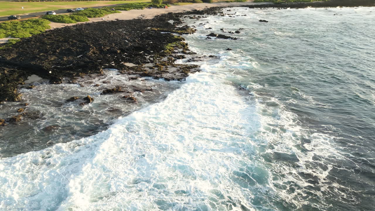 un avión no tripulado retrocede sobre la playa y las rocas en sandy beach, oahu, hawai
