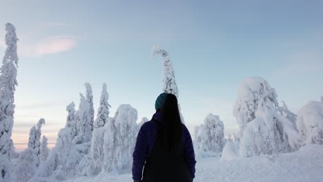 niña admirando el paisaje del país de las maravillas de invierno con enormes árboles cubiertos de nieve en laplandia, finlandia, círculo ártico