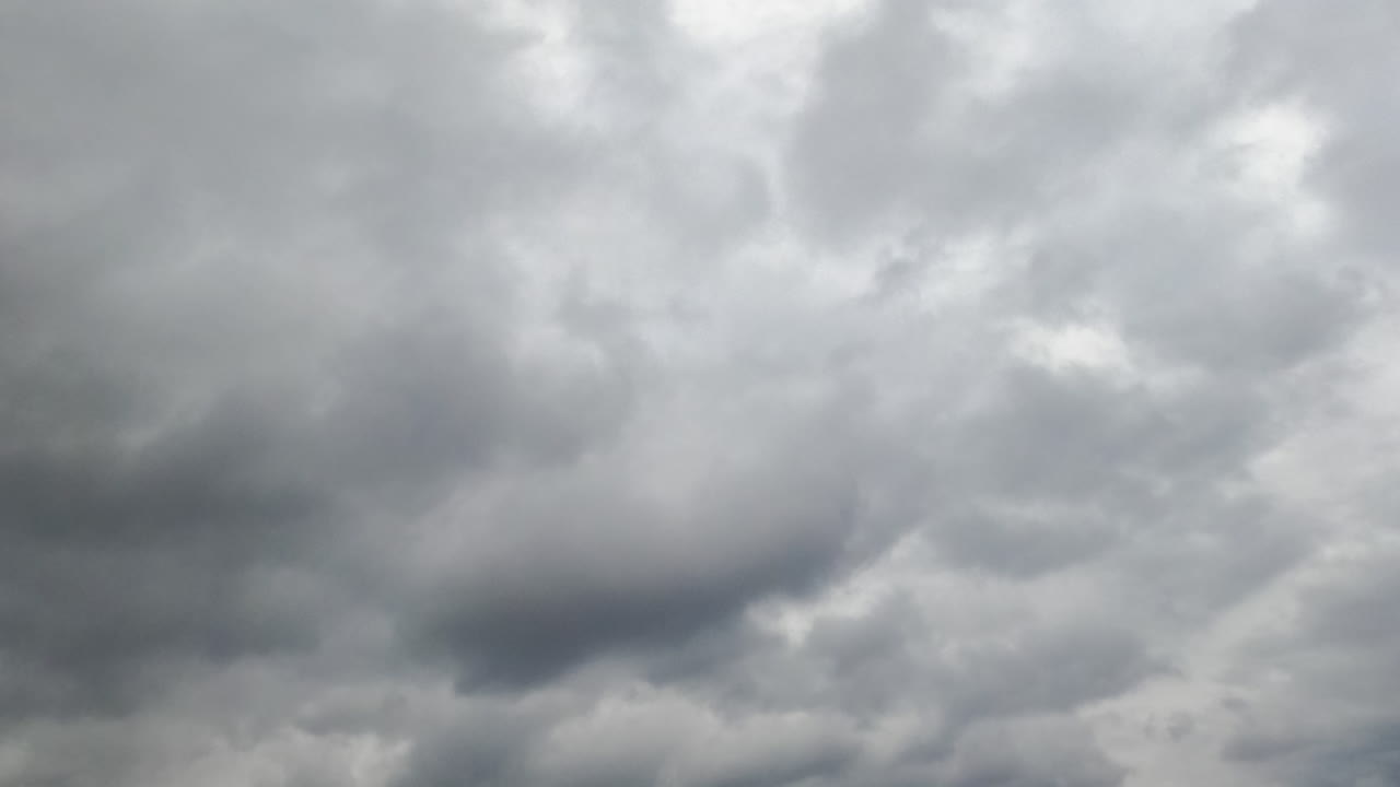 Grey gloomy sky at daytime on bad weather. Rainy clouds covering the skies. Low angle view. Timelapse.