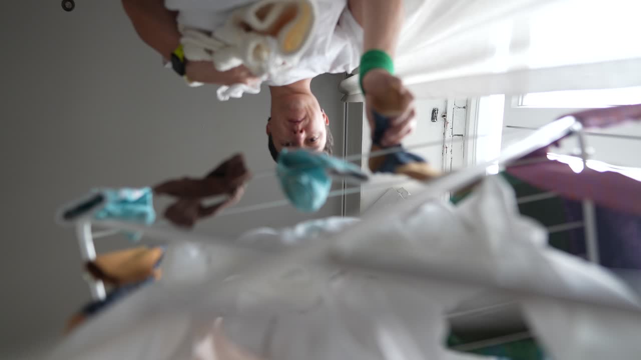 Person Drying Clothes on a Laundry Rack